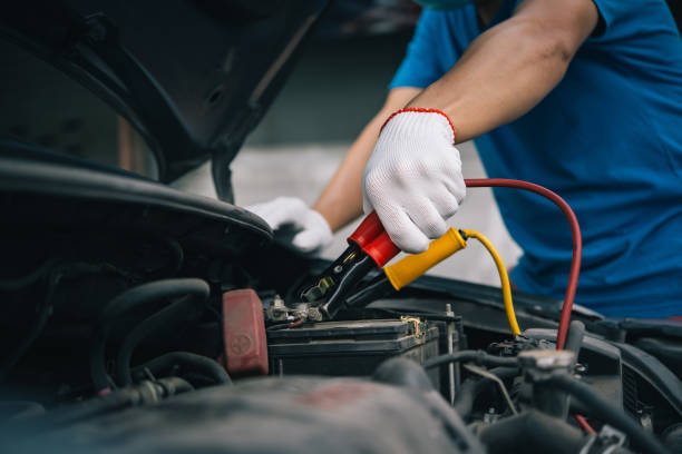 The booster cables and discharged battery,Charging battery car with electricity trough jumper cables.